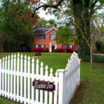 Rosevine Inn . White picket fence in the forground and red brick house in the background.